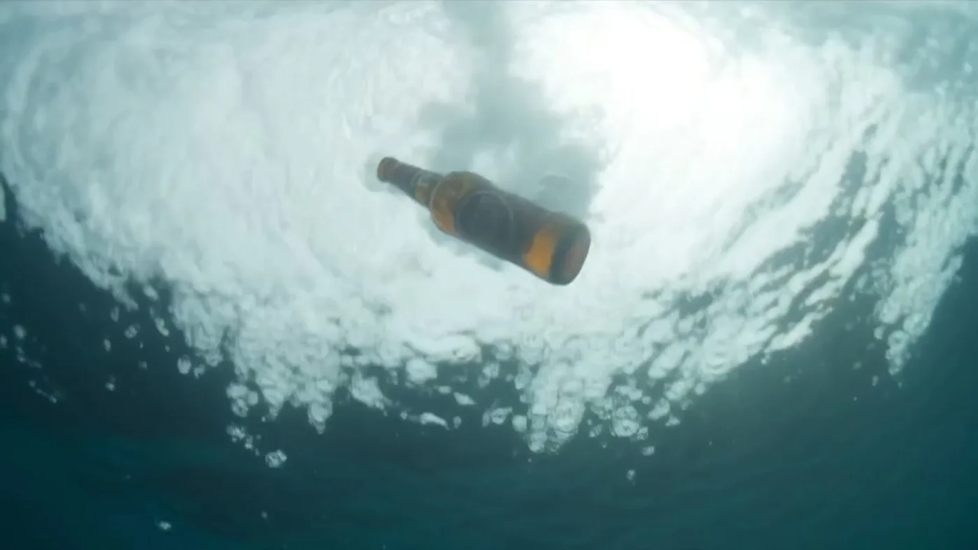Botella de Super Bock hundiéndose en el océano, fotograma generado con IA
